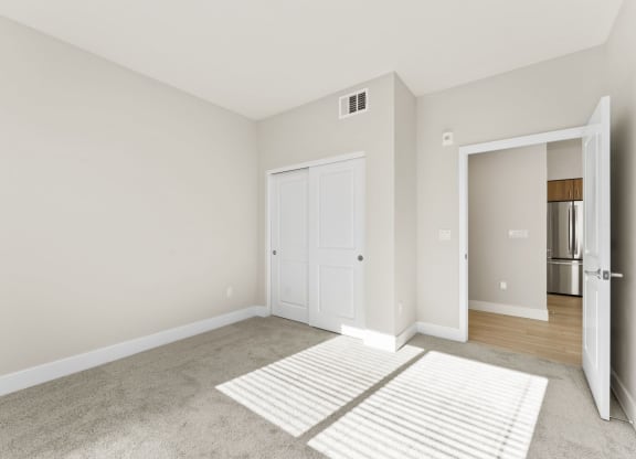 a living room with a rug and a door to a kitchen