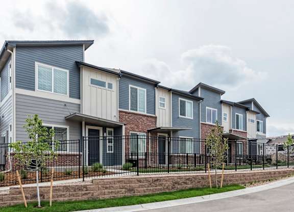 A row of houses with grey and brown exteriors.