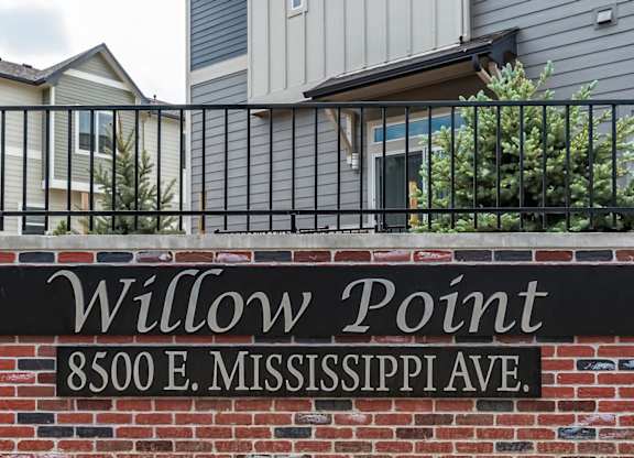 A sign that says Willow Point is on a brick wall.