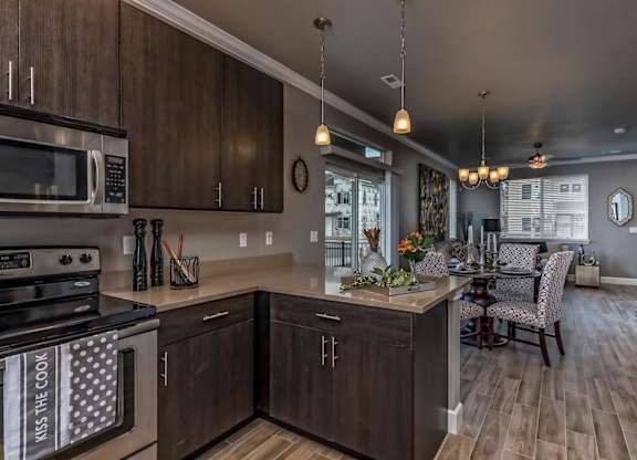A modern kitchen with dark wood cabinets and a large island.