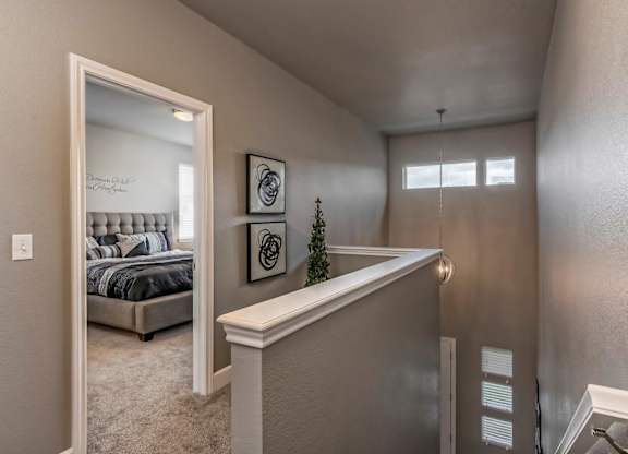 A bedroom with a bed, a mirror, and a small Christmas tree on the counter.