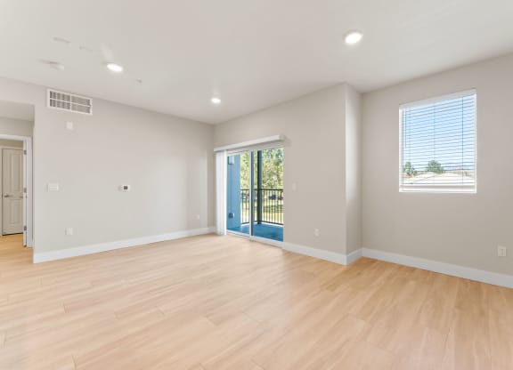 an empty living room with a hard wood floor and a staircase