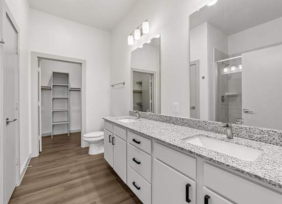 A bathroom with a toilet, sink, and mirror.