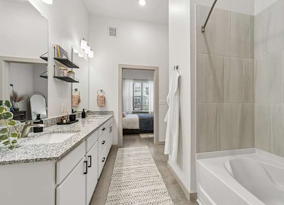 A bathroom with a white tub and a shower.