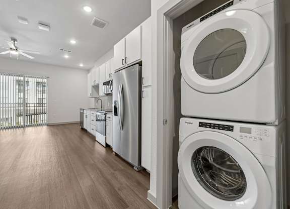 A row of white front loading washing machines in a laundry room.