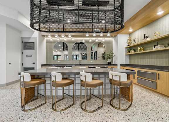A kitchen with a bar area and four stools.
