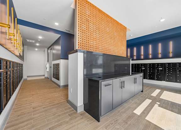 A kitchen with a black counter top and wooden flooring.