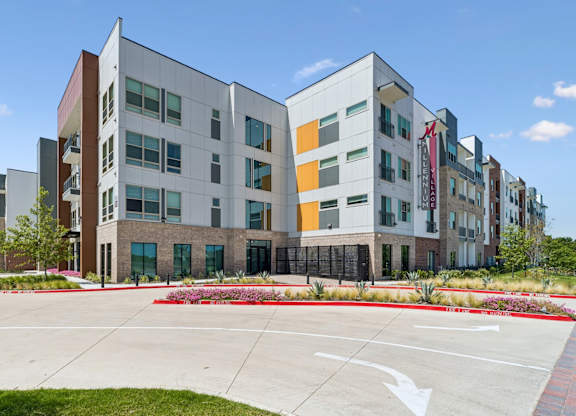 A modern building with a parking lot in front.