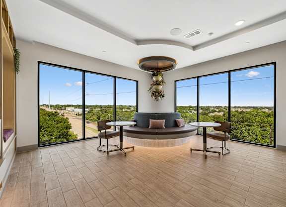 A modern living room with a large window overlooking a green landscape.