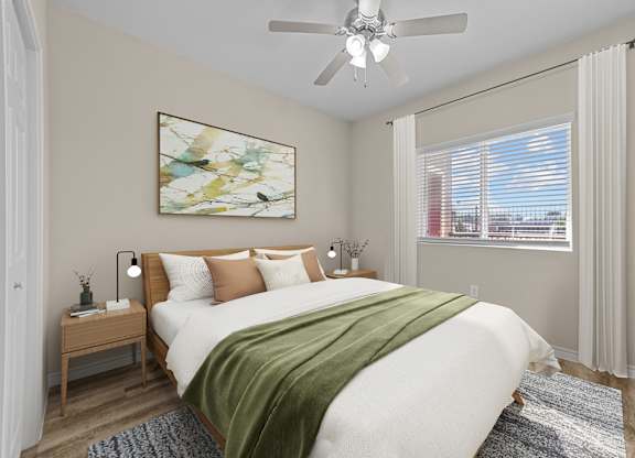 A bedroom with a large bed and a ceiling fan.