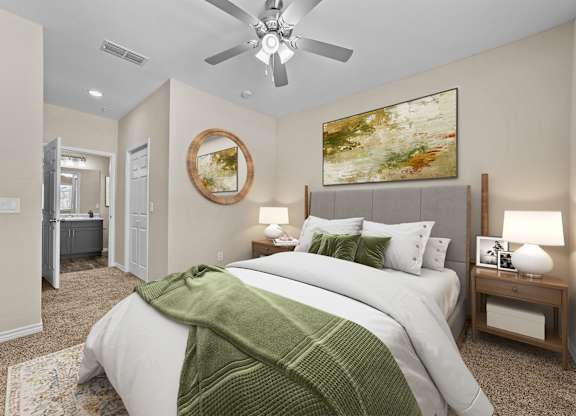 A bedroom with a large bed and a ceiling fan.