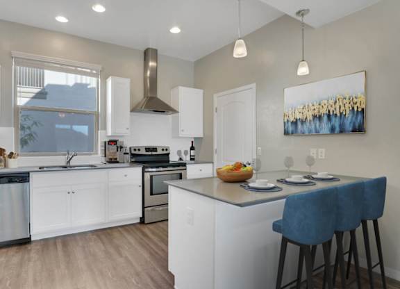 A modern kitchen with white cabinets and a large island.