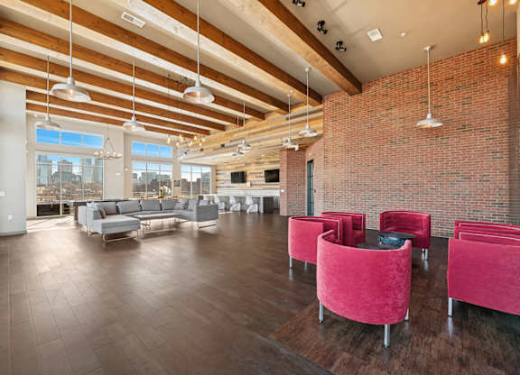 A large room with red chairs and a brick wall.
