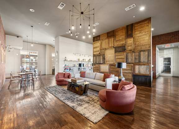 A modern living room with a wooden floor and a large sectional sofa.