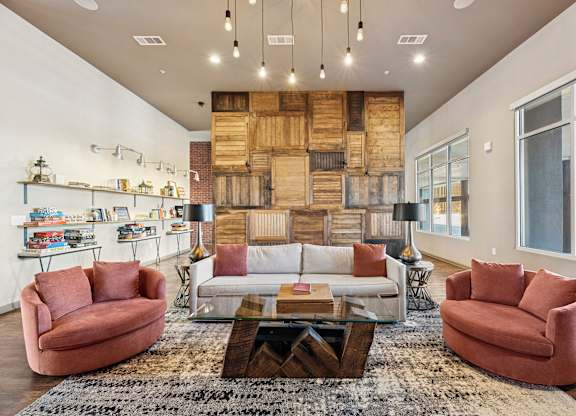 A living room with a white couch, a red chair, and a coffee table.