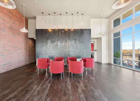 A room with red chairs and a brick wall.