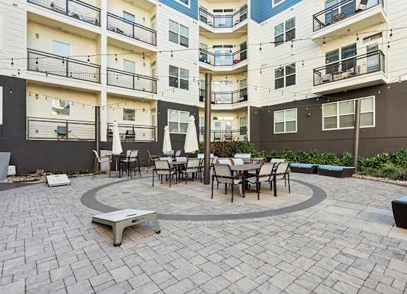 A courtyard with a table and chairs surrounded by apartment buildings.