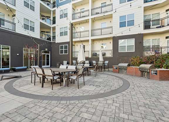 A patio with a table and chairs is surrounded by apartment buildings.