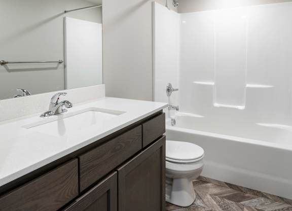 A bathroom with a sink, toilet, and bathtub.