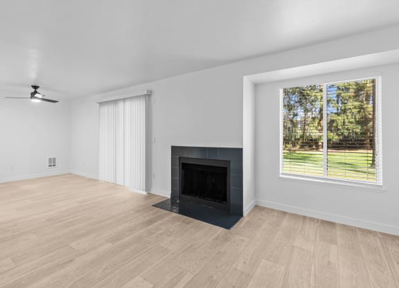 an empty living room with a fireplace and a window