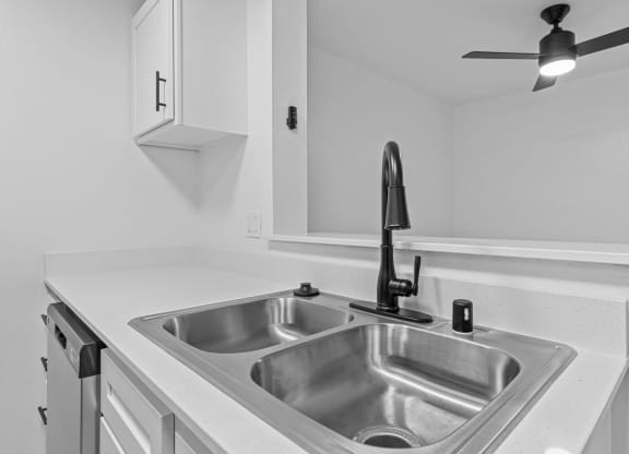 the kitchen of our studio apartment atrium with stainless steel sink and white countertops