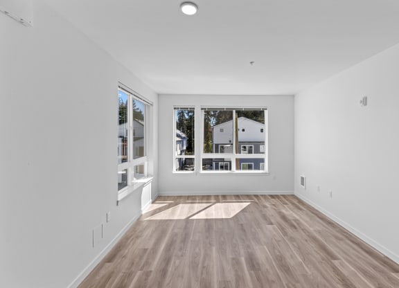 a living room with white walls and a large window