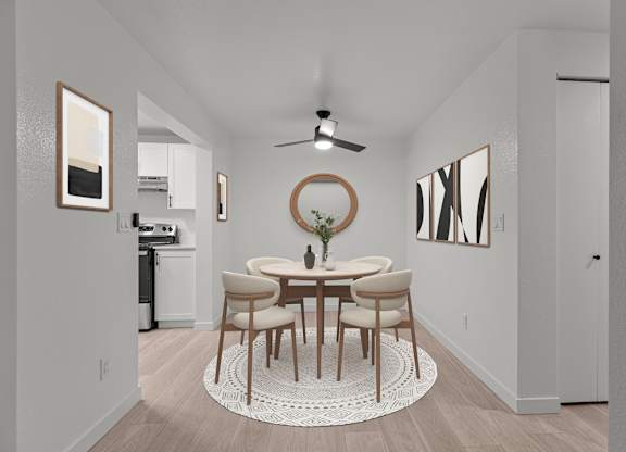 a dining room with a round table and chairs and a ceiling fan