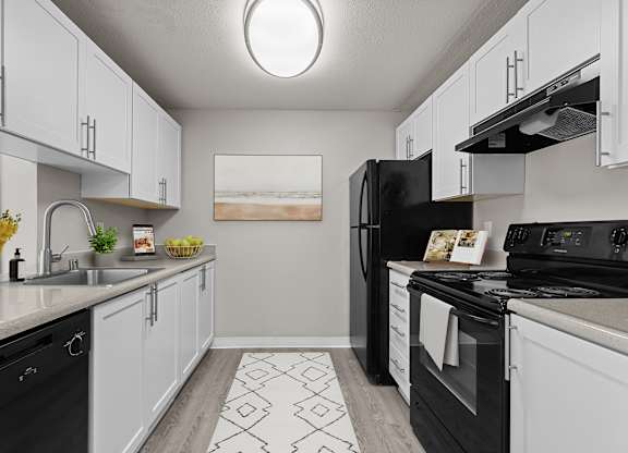 our spacious kitchens are equipped with black appliances and white cabinets