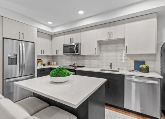 a modern kitchen with stainless steel appliances and a white counter top