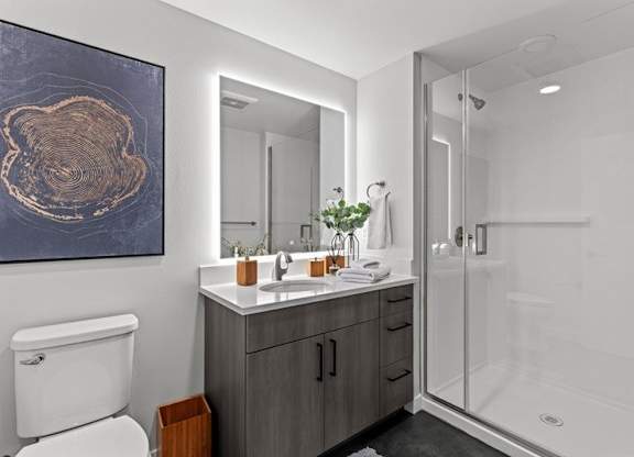 A bathroom with a toilet, sink, and shower.
