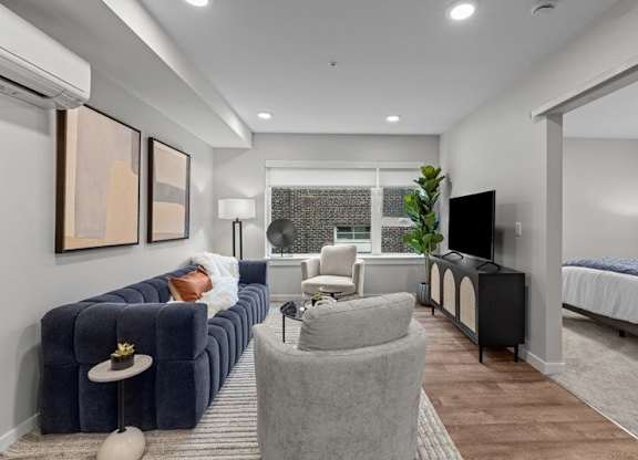 A living room with a grey sofa and a grey armchair.