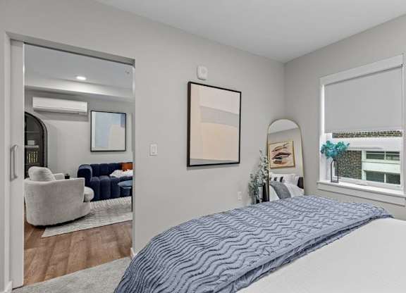 A bedroom with a large bed and a mirror on the wall.