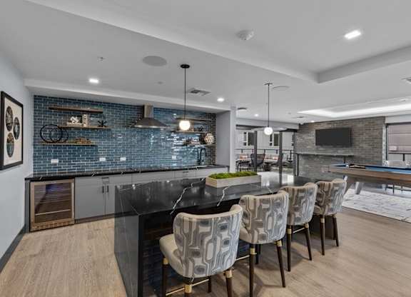 A modern kitchen with a black countertop and a bar area.