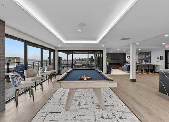 A billiard table is in the middle of a room with a brick wall and a pool table.