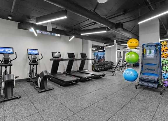 A gym with treadmills, exercise bikes, and a rowing machine.