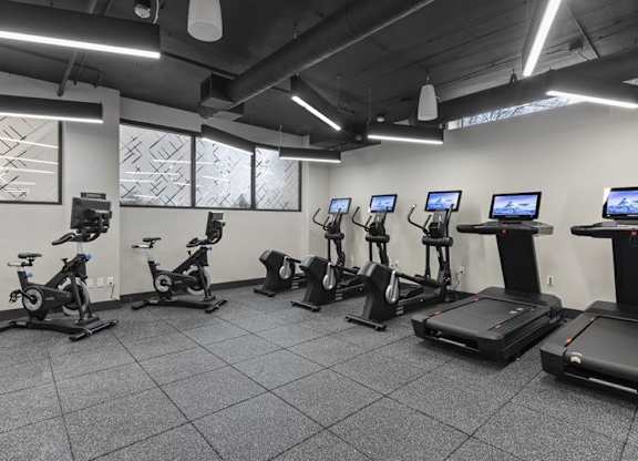A gym with treadmills, exercise bikes, and elliptical machines.