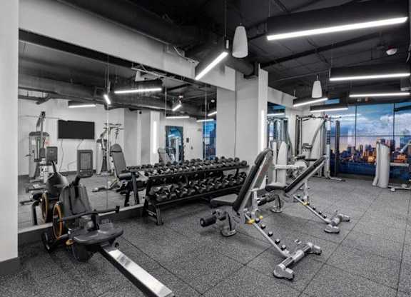 A gym with a variety of equipment including weights and machines.