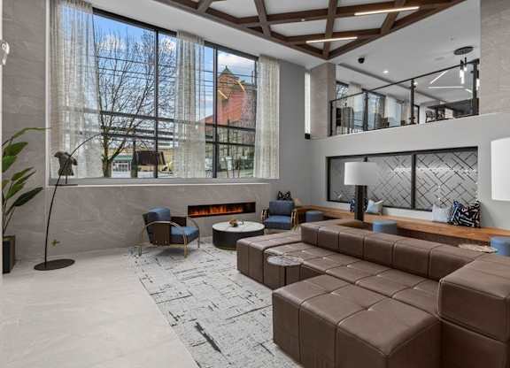 A modern living room with a large window and a fireplace.