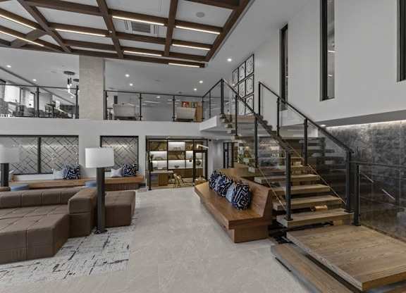 A modern living room with a staircase and a couch.