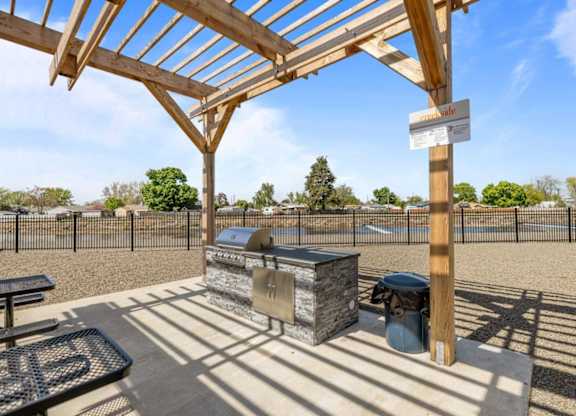 A wooden pergola with a sign that reads