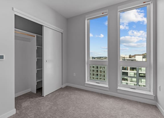 the living room of an apartment with windows and a view of the city
