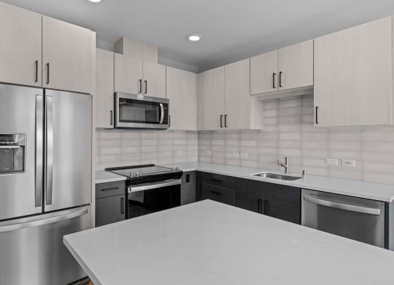 an all white kitchen with stainless steel appliances and white counter tops
