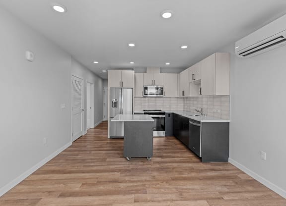 a renovated kitchen with white cabinets and stainless steel appliances