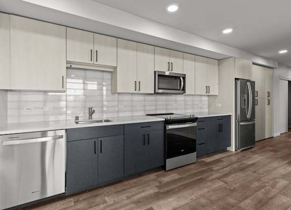 A modern kitchen with dark wood floors and white appliances.