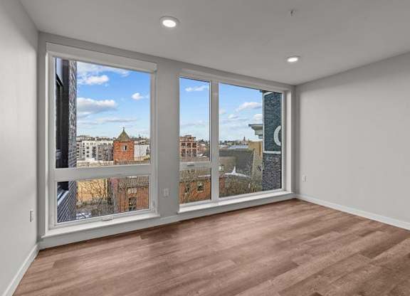 A room with a large window overlooking a cityscape.