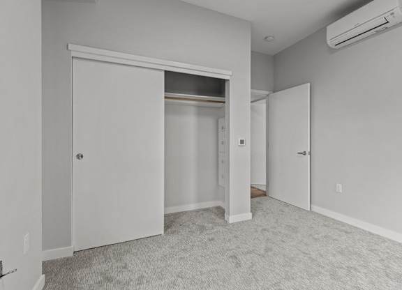 A room with a carpeted floor and a sliding door.