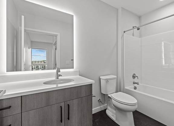 A white bathroom with a toilet, sink, and bathtub.