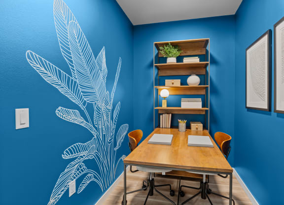 a conference room with blue walls and a wooden table and chairs