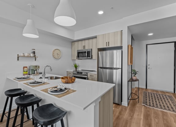 a kitchen with a white counter top and a stainless steel refrigerator