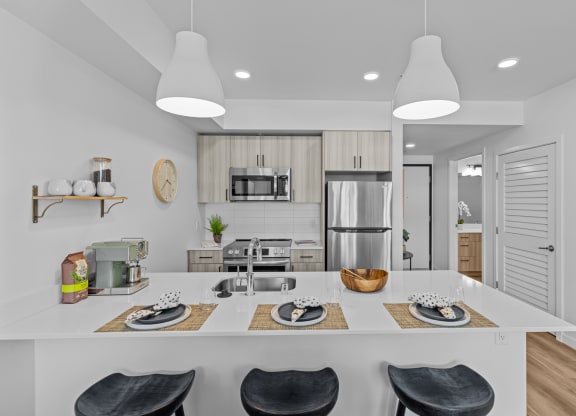 a kitchen with a large island and a stainless steel refrigerator